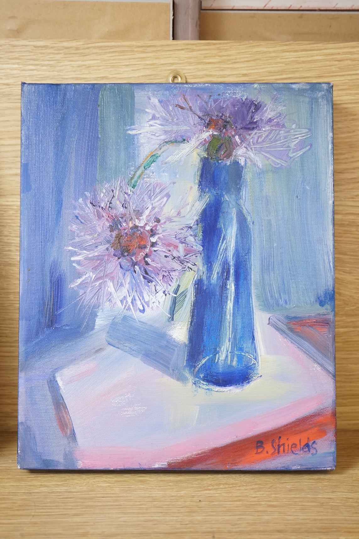 B. Shields, Still life of cornflowers, signed, oil on canvas, together with another, titled 'White flower in blue pot, tempura on canvas board, largest 30 x 24cm, one unframed